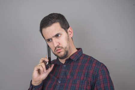 Portrait of man using a smart phone with checkered shirtの写真素材