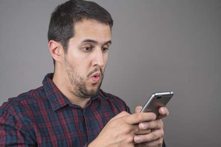 Portrait of surprised man talking on smartphone