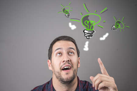 Young man with an idea lights a light bulbの写真素材