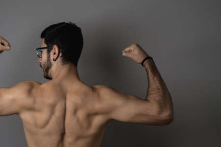 Muscular young man posing with definitionの写真素材