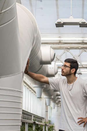 young man working on ventilation ductsの写真素材