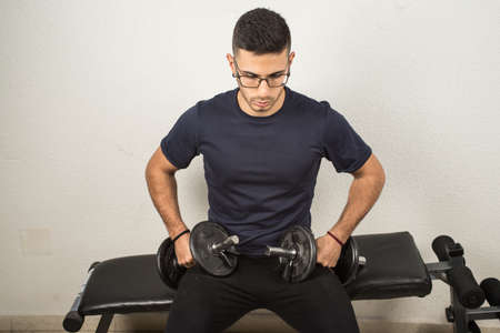 Man exercising with dumbbells, dumbbell exercise to stayの写真素材