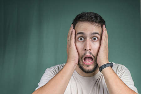 man with hands on face scaredの写真素材