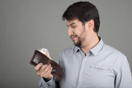 young man with a beard, with euros in his handの写真素材