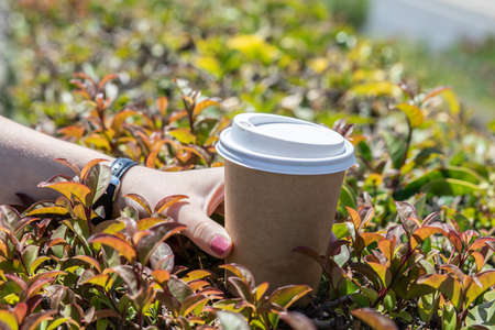 Hand holding a cup, paper coffee cup with delicious coffee, the design of your coffee shopの写真素材