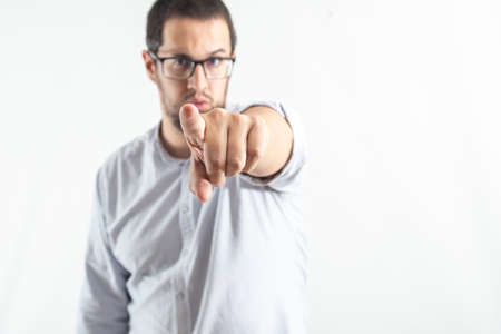 Young business man pointing with his finger. Motivational image. white background portraitの写真素材