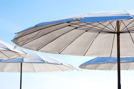 part of a white umbrella on the beach and blue sky