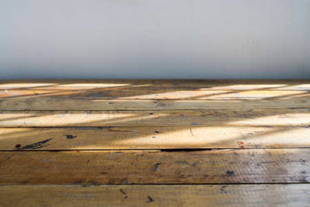 Empty wooden table and empty space background with light shadow from windowの写真素材