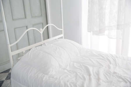 White themed bed and white curtain in the morning, bedroom interiorの写真素材