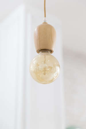 Vintage light bulb hanging on white background.