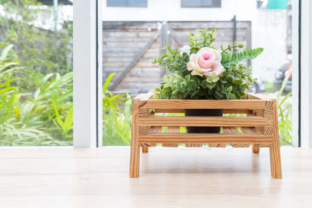 artificial romantic plant in basket on wooden table with garden background.の写真素材