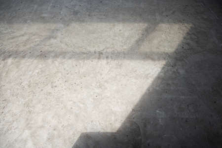 cement wall with light shadow of grille, abstract background.の写真素材