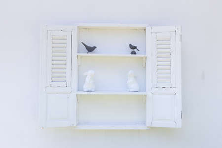 front view of wooden small cupboard with white rabbit and black bird statue.の写真素材