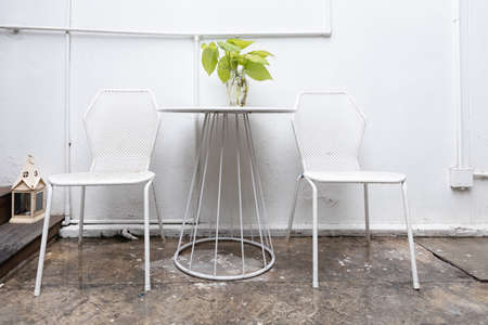 modern metal white chair and table at outdoor cafe in rainy day.の写真素材