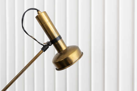 close up of rustic brass metal adjustable arm lamp on white wall background.の写真素材