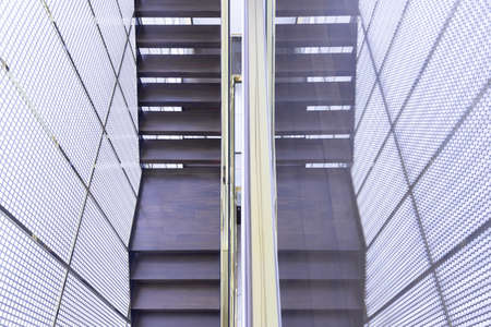 architecture of luxury wooden staircase with glass railing and gold handrail in golden grille house interior.の写真素材