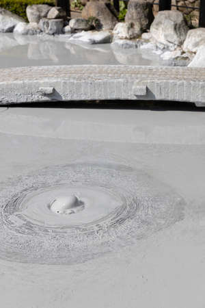 landscape view of gray mud boiling bubble hot springs at Japan.