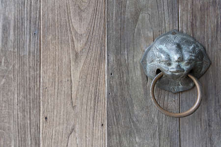 close up of old wooden with lion or tiger shape door knob and handle ring.の写真素材