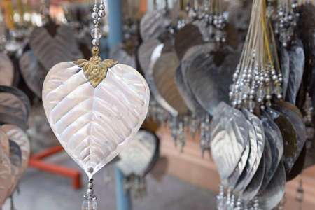 close up of silver bodhi plate leaf hanging by temple buddhism worshipers for fortune.の写真素材