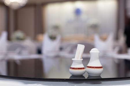 closeup of toothpick holder and pepper pot on Chinese dinner banquet table in a restaurant,...
