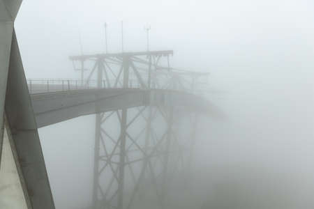 outdoor cable car station with foggy landscape at hill or mountain peak