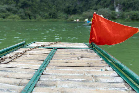 bamboo boat trip with beautiful blurred mountain and green river, selective focus.の写真素材