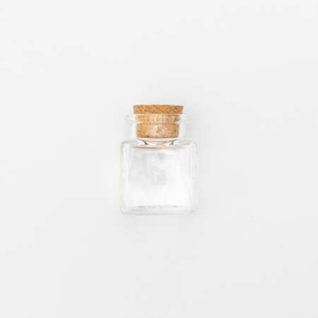 top view of transparent blank glass jar bottle with closed brown cork cap lids on white background