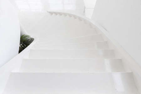 high angle view of white indoor cement staircase without railing in minimal building
