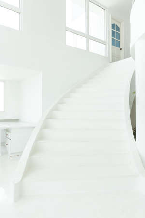 front view of white indoor cement staircase without railing in minimal building