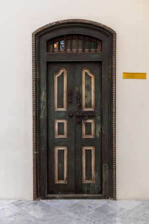 front view of vintage wooden door with rusty old slide or tower boltの写真素材