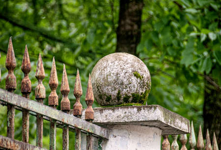 A stone ball on a wrought iron fence in the park. High quality photoの写真素材