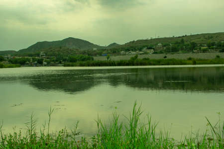The landscape of the mountains in the background. Green grass and blue sky.の写真素材