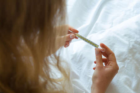 Woman's hand holding thermometer