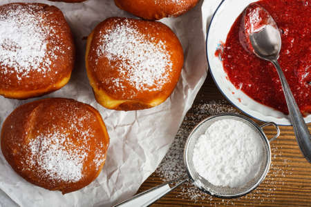 Homemade doughnuts filled with rose marmalade on wooden table.の写真素材