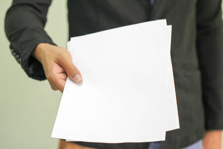 Business man holds paper with copy space  focus on hand holding paper  の写真素材