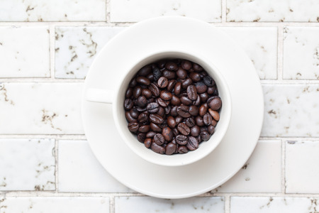 Cup full of coffee beans on Marbleの写真素材