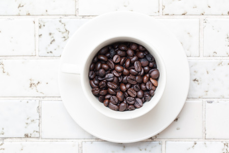 Cup full of coffee beans on Marbleの写真素材
