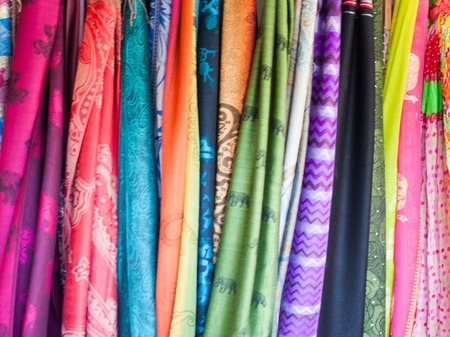 Rows of colourful silk scarfs hanging at a market stall in Rayong, Thailandの写真素材