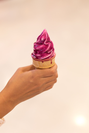Ice cream in woman hand outdoors. Selective focus.