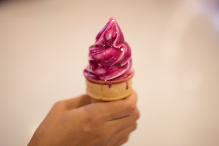 Ice cream in woman hand outdoors. Selective focus.