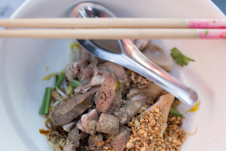 Spicy dry pork ball noodle in white bowlの写真素材