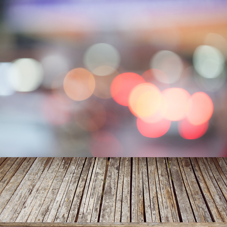 Wood table top on bokeh abstract car light background - can be used for montage or display your productsの写真素材