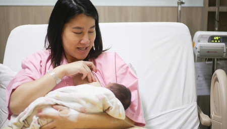 A mom breastfeed her baby motherhood and kid drink milk by mother chest is benefitの写真素材