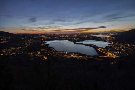 Sunset and night lights on the northern lakes of Lombardiaの写真素材
