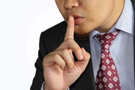 male businessman with finger mouth shh gesture