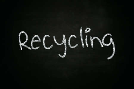 The word Recycling written with chalk on blackboardの写真素材