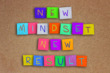 The words New Mindset New Result written on sticky colored paper over cork boardの写真素材