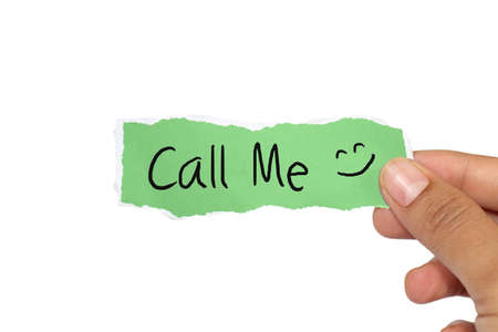 Image of a hand holds ripped paper with the words Call Me written on it isolated on whiteの写真素材