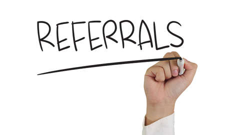Image of a hand holding marker and write referrals word isolated on whiteの写真素材