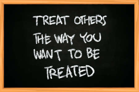 The words Treat others the way you want to be treated written with chalk on blackboardの写真素材